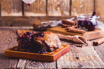 Roasted chicken.  Cranberry sauce pouring over chicken legs