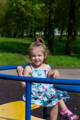 Fototapeta na wymiar the little girl shakes on a swing in the park