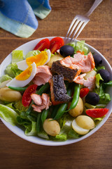 Salad Nicoise with salmon. Tomato, green beans, new potato, olives and lettuce salad with salmon. vertical