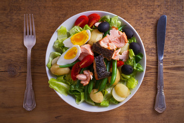 Salad Nicoise with salmon. Tomato, green beans, new potato, olives and lettuce salad with salmon. overhead, horizontal
