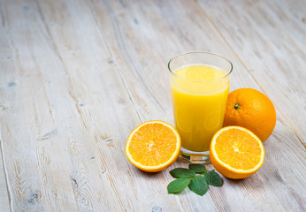 Orange juice and citrus fruits on rustic wooden table with copy space