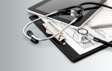 Modern laptop and stethoscope on wooden background