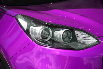 Modern headlight of a beautiful new car lilac. car light. glossy new car