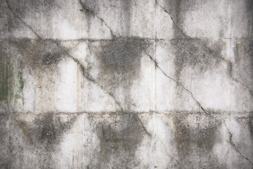 Close-up of rough texture of aged gray concrete wall with geometric pattern relief, with dirty flow marks.