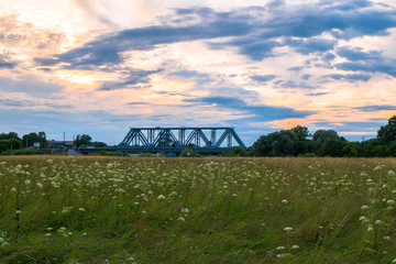 Evening sky over the railway bridge and flowered Bogolyubovo meadow, Vladimir region.