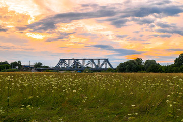 Evening sky over the railway bridge and flowered Bogolyubovo meadow, Vladimir region.