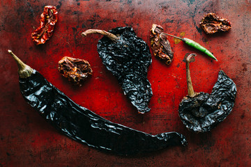 dried chilies on red baking sheet, dark, moody, bold