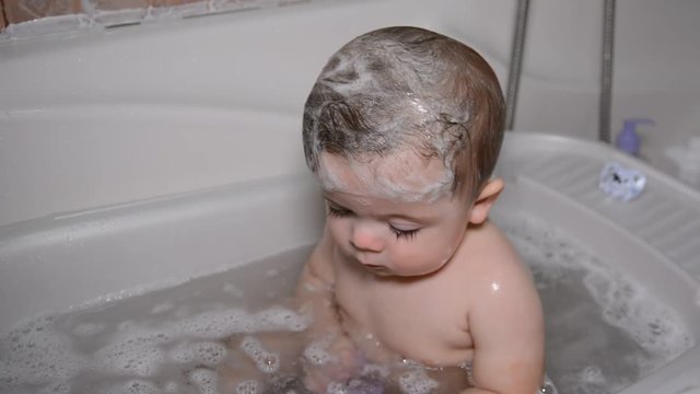 Bath for babies, baby wash your hair. Happy boy taking a bath.