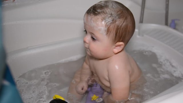 Bath for babies, baby wash your hair. Happy boy taking a bath.