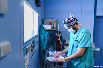 Surgical assistant writing down on a sheet of paper