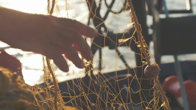 Greek fisherman untangling fishing nets during sunset slow motion cinematic beautiful