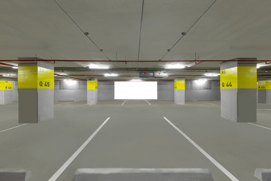 Parking garage underground interior with blank billboard.