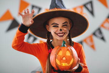 happy   child girl in pumpkin costume to halloween.