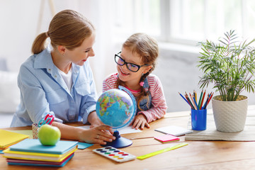 Fototapeta premium mother and child daughter doing homework geography with globe