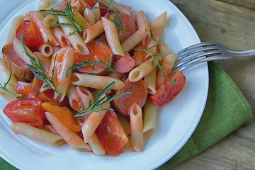 Penne pasta in tomato sauce with sauseges, tomatoes and sweet pepper.