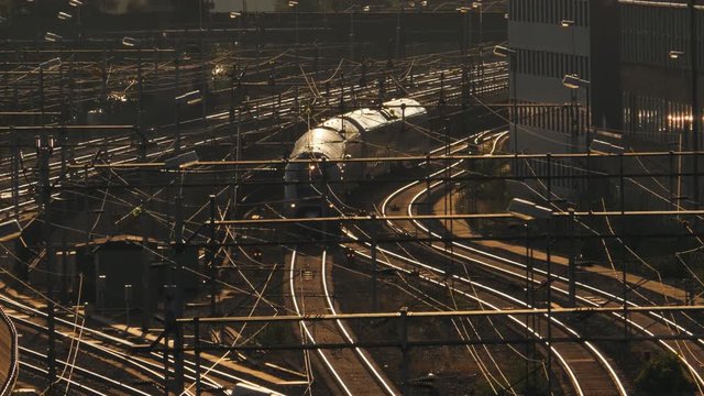 AERIAL SHOT of a train arriving train station in a beautiful sunset in Stockholm, Sweden. Filmed in SLOW MOTION.