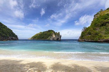 Shade and calm surf at Atuh Beach, a popular tourist area of Nusa Penida.