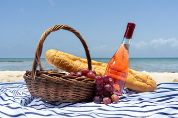 Beach picnic with wine, baguette bread and grapes