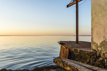 colorful sunset over water surface, evening sun over the bay, summer sky without clouds