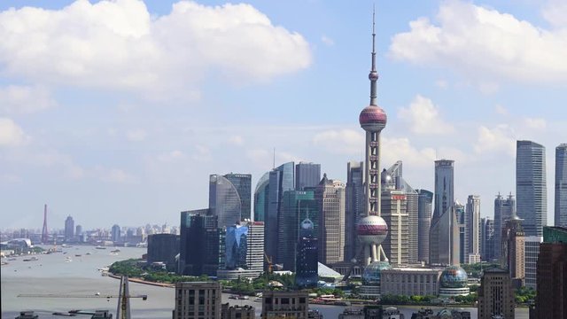 Shanghai Lujiazui and Huangpu river timelapse. Chinese city downtown time-lapse with beautiful clear day with white fluffy clouds. Cityscape of Pudong in urban China in daytime.