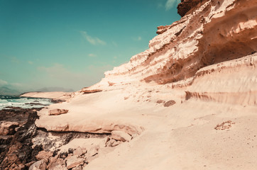 nature poster. yellow sand rock and blue ocean