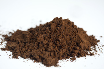 Pile of grounded coffee on a white background