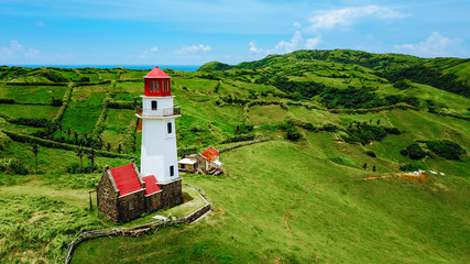 Drone shot of Mahatao Tayid Lighthouse on top rolling hills in the province of Batanes, Philippines