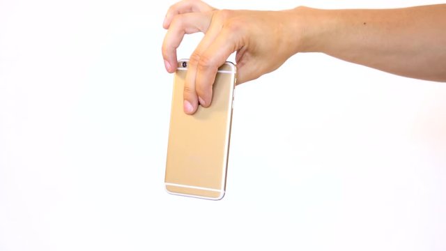 Dropping phone on purpose. Letting go of smartphone to drop to the ground and smash. Garbage old electronics thrown away to the floor by hand.