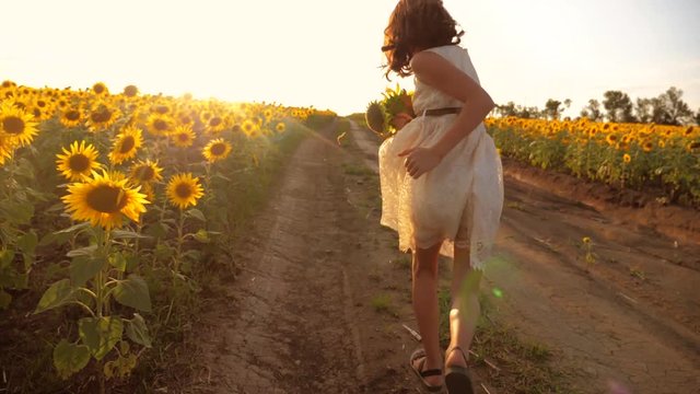 little girl running across the field with sunflowers at sunset. slow motion video. girl runner in the field at sunset sunflowers. girl sunlight runs the concept of sunflowers lifestyle
