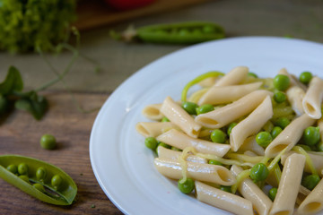 Penne pasta with green peas, zucchini noodle  and herbs