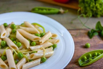 Penne pasta with green peas, zucchini noodle  and herbs