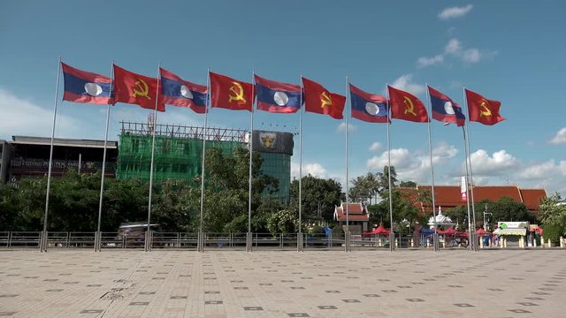 VIENTIANE,  LAOS - CIRCA AUGUST 2018 : LAOS NATIONAL FLAG and COMMUNIST FLAG waving in the wind.