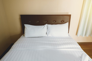 Fototapeta na wymiar White pillow on bed decoration in bedroom