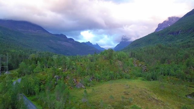 Drone footage while taking off and revealing the Innerdalen valley in Norway, on a cloudy evening.
The top of the mountain is covered in fog.