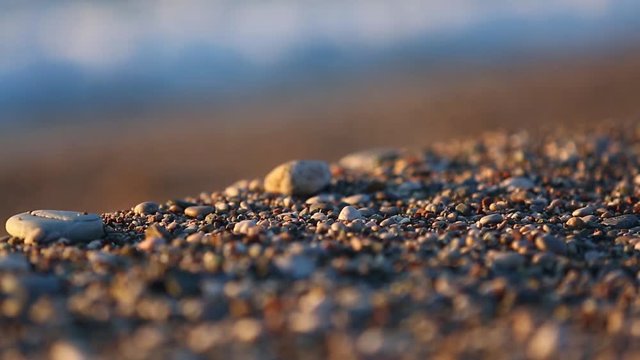beautiful blurred highlights and bokeh on the beach pebbles at the sunrise, Antalya, Turkey. Selective focus.