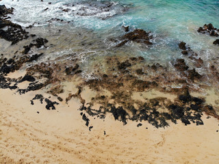 Fototapeta na wymiar Aerial view of a black volcanic rock beach in Wailea, Maui, Hawaii