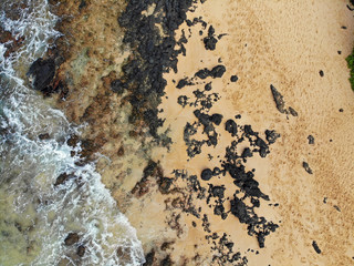 Aerial view of a black volcanic rock beach in Wailea, Maui, Hawaii