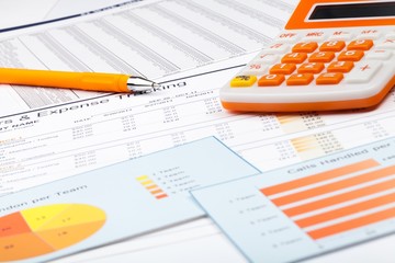 Obraz premium Pen and Calculator on Business Graphs and Charts
