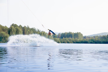 Naklejka premium Young man riding wakeboard on a lake