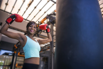 lifestyle indoors gym portrait of young attractive and beautiful black afro American woman training happy posing playful wearing boxing gloves