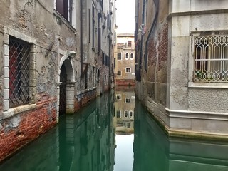 Quiet canal in venice italy with still water