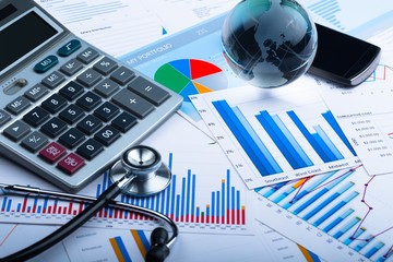 Obraz premium Smartphone, Glass Globe, Stethoscope and Calculator on Business