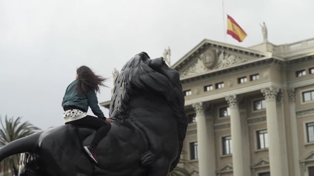 Girl on Top of Lion Statue And Spanish Flag
