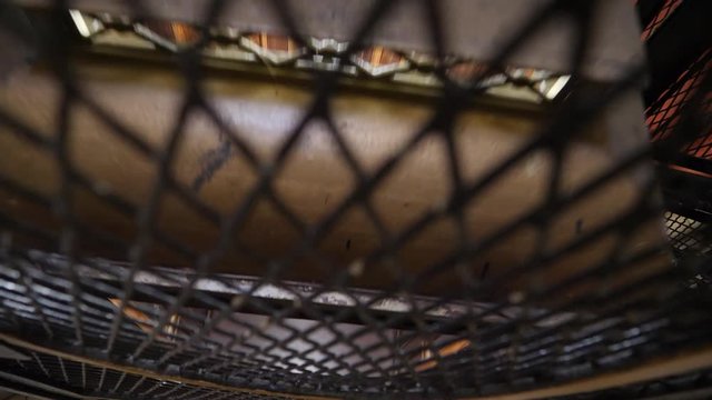 Looking down a vintage elevator shaft as it descends and goes down through a building