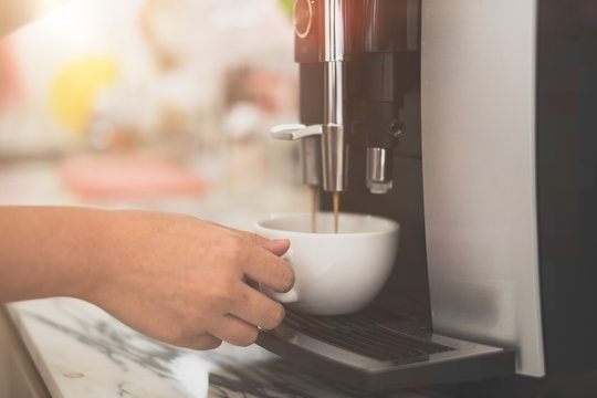 Woman making fresh espresso in coffee maker. coffee machine makes coffee. Barista Coffee Maker Machine Grinder Portafilter Concept