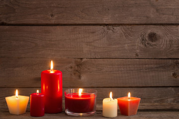 Obraz na płótnie Canvas red and white candles on dark wooden background