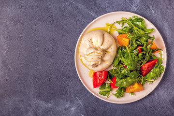 Italian cheese Burrata with fresh arugula, tomatoes, olive oil