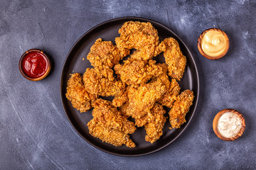 Fried chicken wings with various sauces.