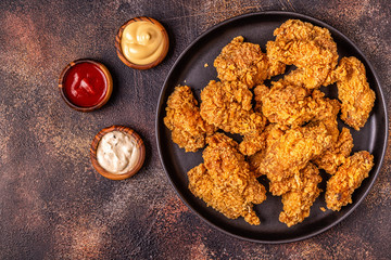 Fried chicken wings with various sauces.