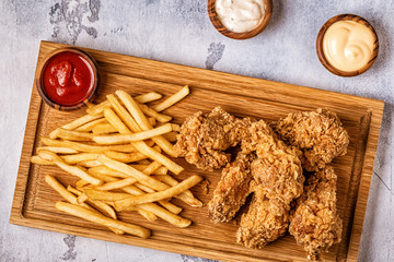 Naklejka premium Fried chicken wings with french fries.